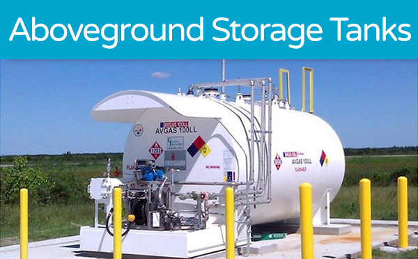 White aboveground storage tank with safety labels surrounded by yellow bollards in a field.