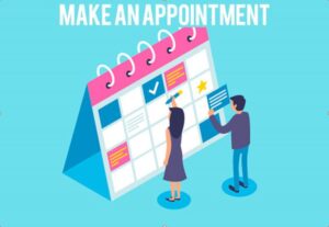 Two people scheduling appointments on a large wall calendar.