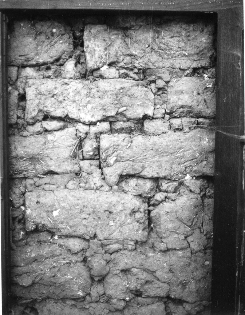 Close-up view of an old stone wall texture with visible layers of irregular-shaped stones and mortar