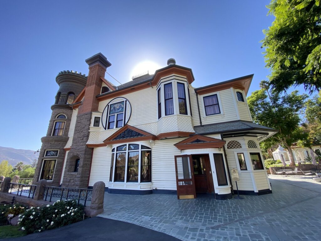 Angle view of a Victorian-style house with a round tower and wrap-around porch