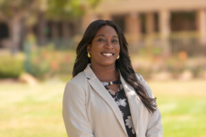 Smiling professional woman in a light blazer standing outdoors