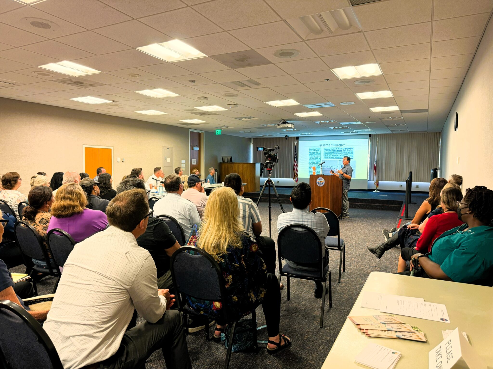 Community members attending a local government cultural heritage presentation in a conference room.