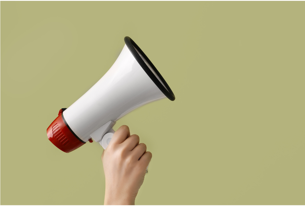 Hand holding a megaphone on a green background