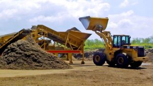 Tractor and equipment for processing mulch at a work site