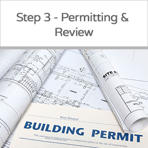 Rolled blueprints and a printed building permit document, symbolizing building permitting and review process.