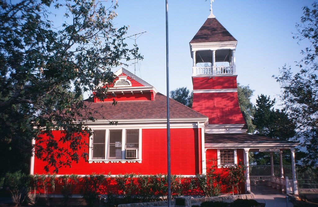 Santa Clara Schoolhouse, a vibrant red building with a tall, square tower, 1982.