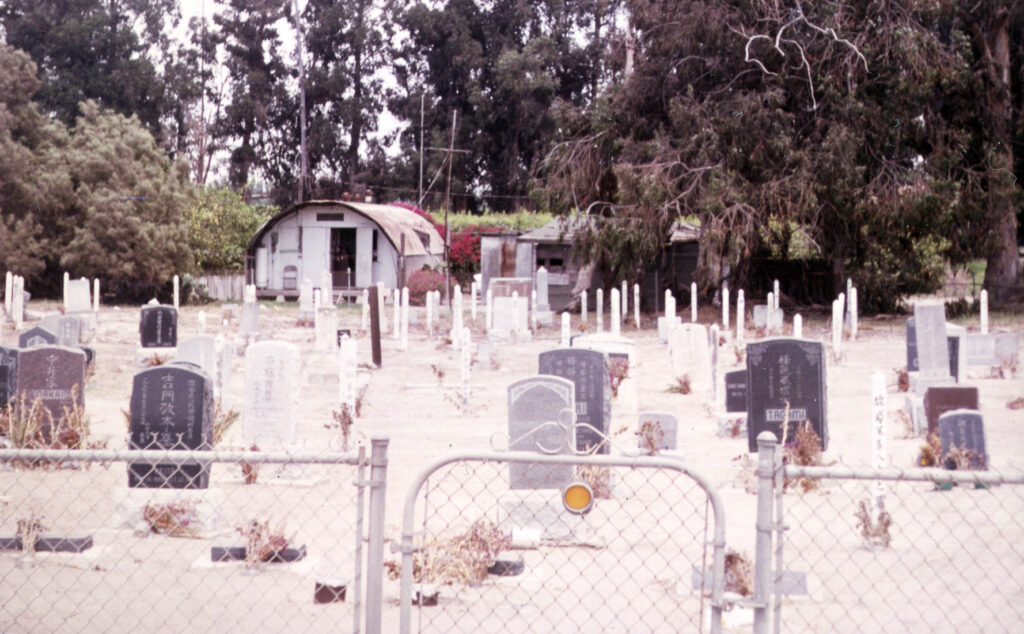 View of Japanese Cemetery with grave markers through a chain link fence