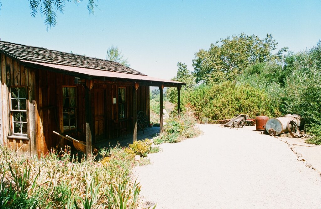 Stagecoach Inn property grounds with historical wooden building and garden, taken in 1985.