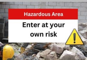 Construction site with a warning sign: "Hazardous Area - Enter at your own risk" on a red and white background with a caution symbol.