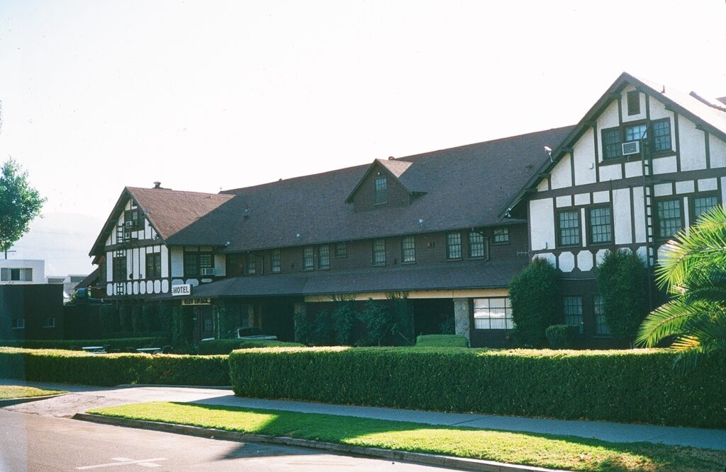 Glen Tavern Hotel, 1985, features Tudor-style architecture with white and brown half-timbering, a brown roof, and a visible "HOTEL" sign, surrounded by manicured hedges and a sidewalk.