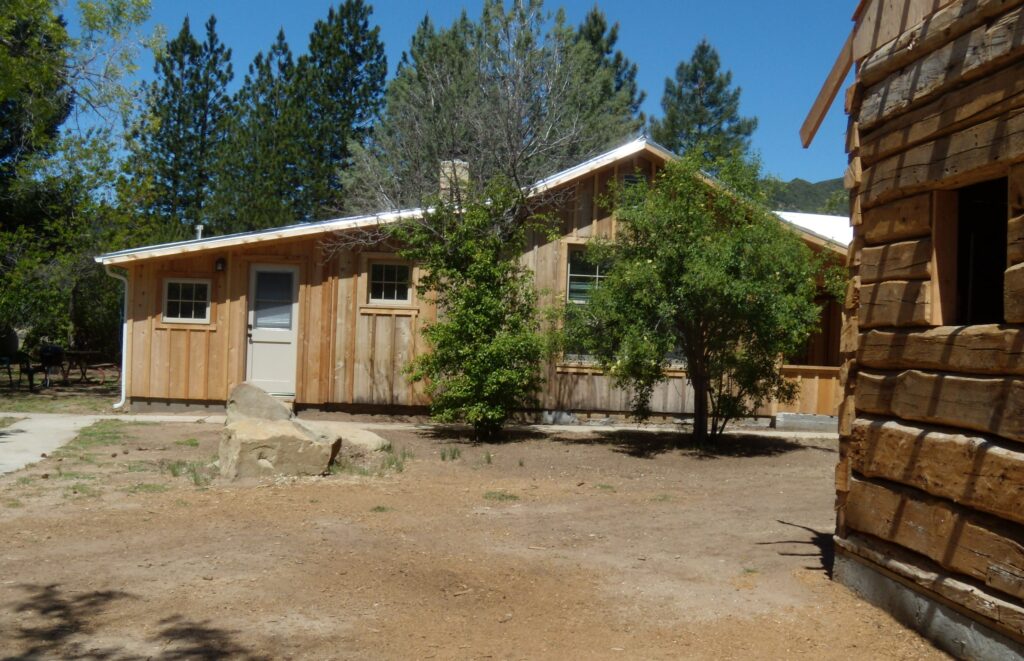 Wooden cabin with stone and trees, part of Lathrop Camp's 2011 rehabilitation project.
