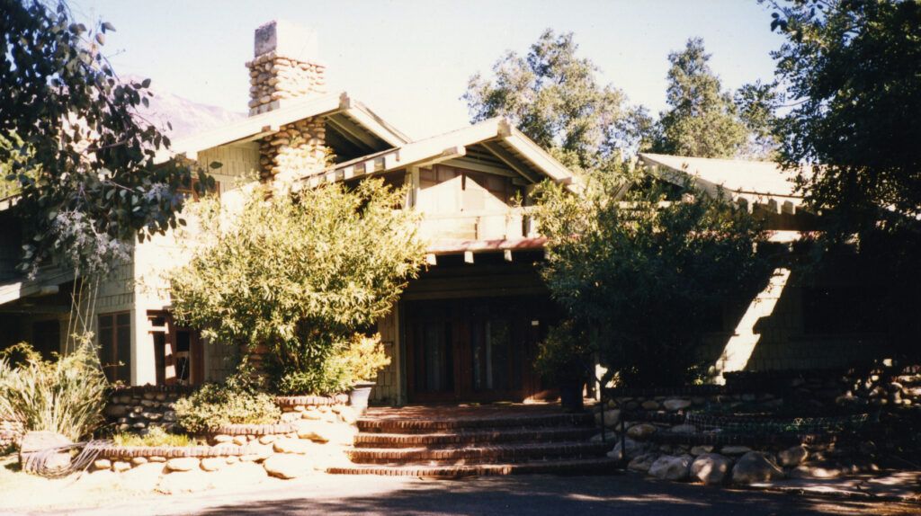 Pratt House, a mid-century modern home with a stone chimney, wooden siding, and landscaped garden, circa 1980s.