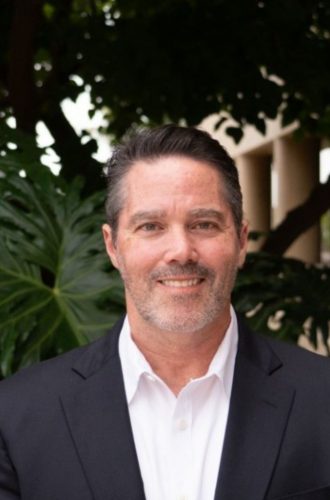 Portrait of a man in a black suit, outdoors