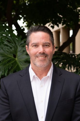Portrait of a man in a black suit, outdoors